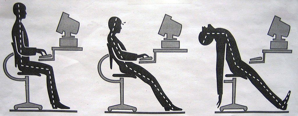 Office worker struggles at the computer and leans back over their chair in frustration