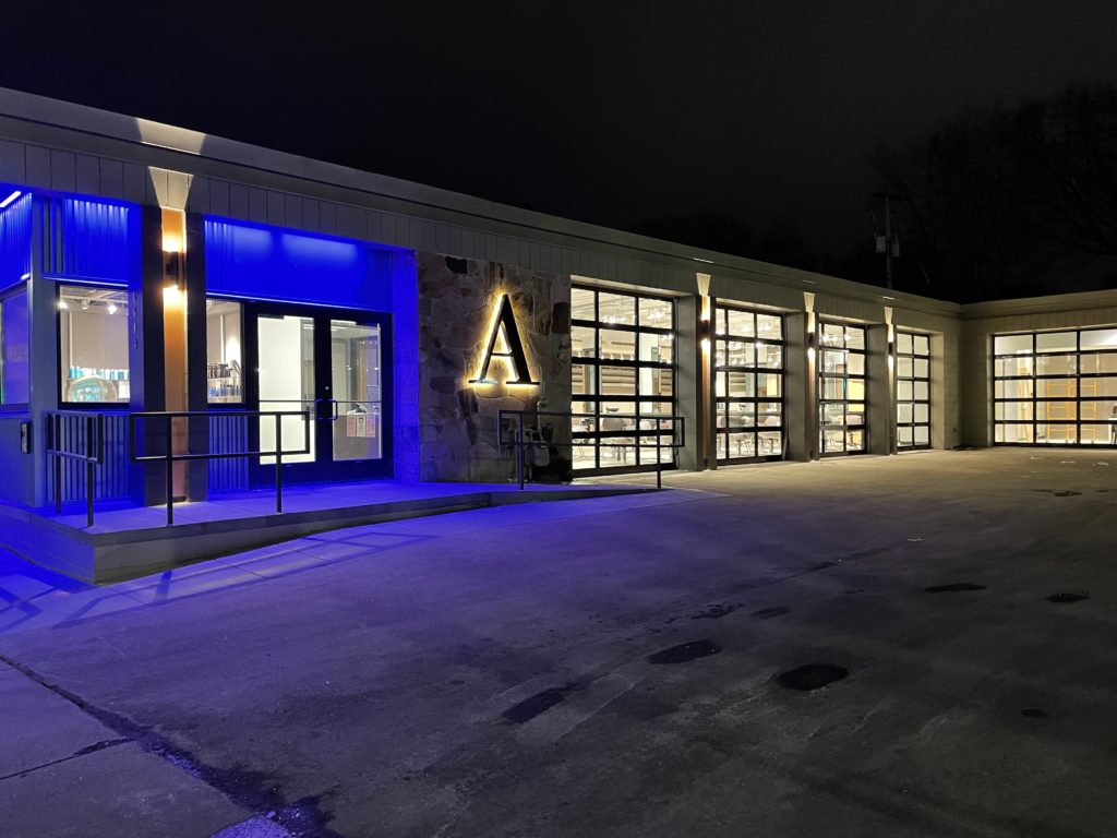 The exterior of the Atelier Academy of Beauty lit up by blue light.