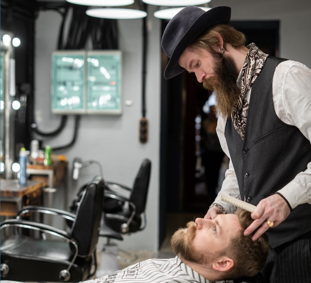Barber examines and trims a client's beard