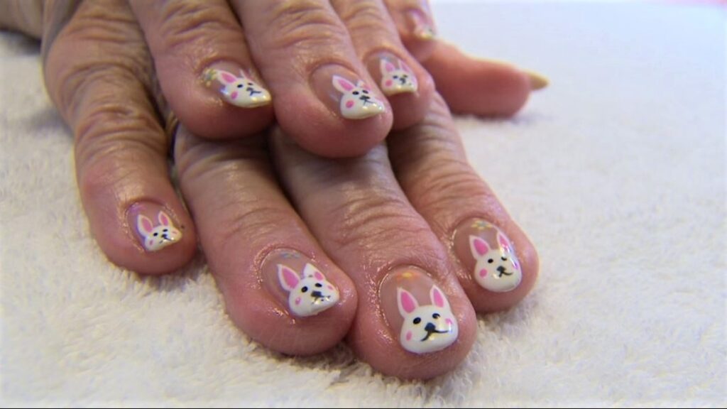 A senior from the Good Samaritan Society shows off finger nails painted with white bunnies on the tips