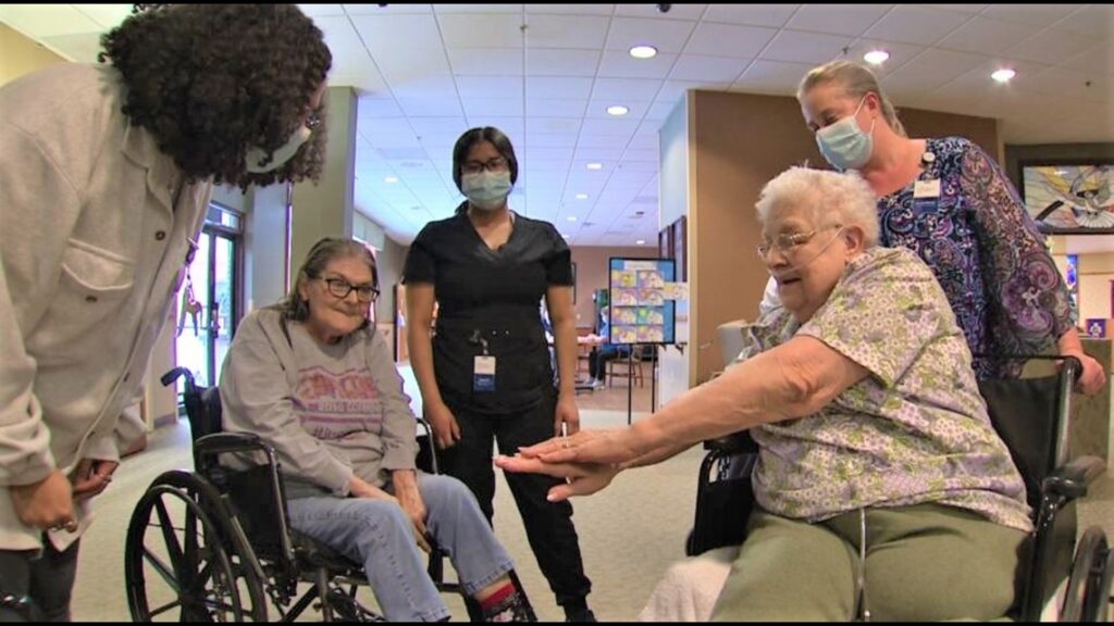 Senior at the Good Samaritan Society shows off newly painted nails to other residents and staff