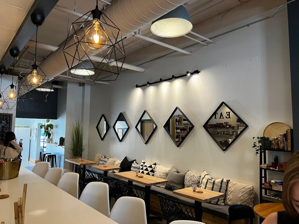 A view of the bar and pillowy seating in front of a wall of diamond shapes mirrors at the Vine room in Hopkins, MN.