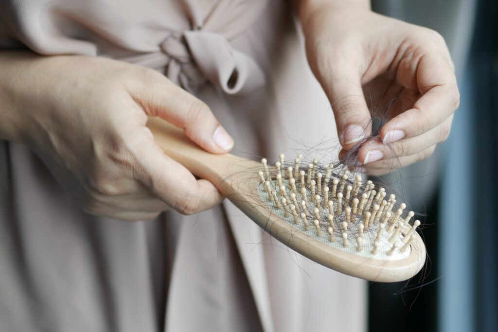 Person pulls hairs out of brush