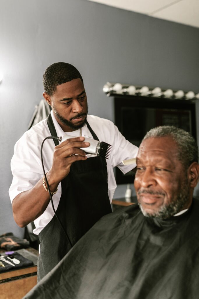 Man gets a clipper cut by barber or hair technician