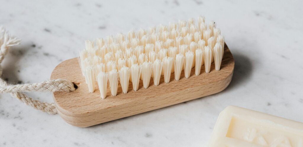 A typical nail brush for cleaning excess debris from nails is a rectangular, short brush with several rows of short, clustered bristles