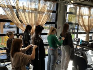 3 students with their backs turned to the camera cuz 3 clients' hair
