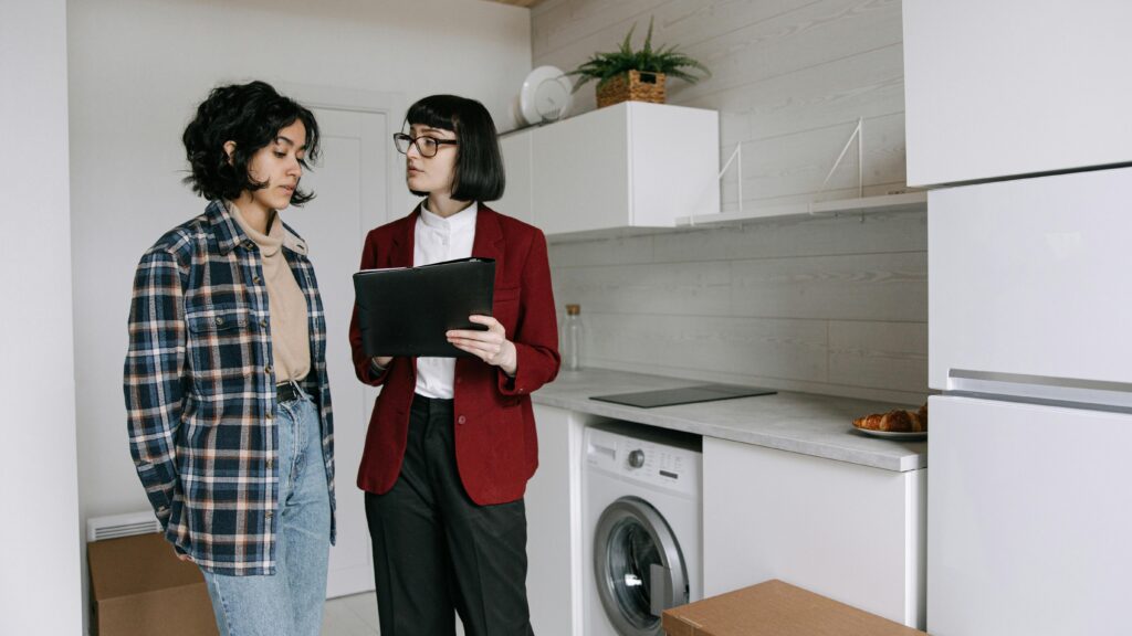 A real estate agent takes a potential renter around an apartment.