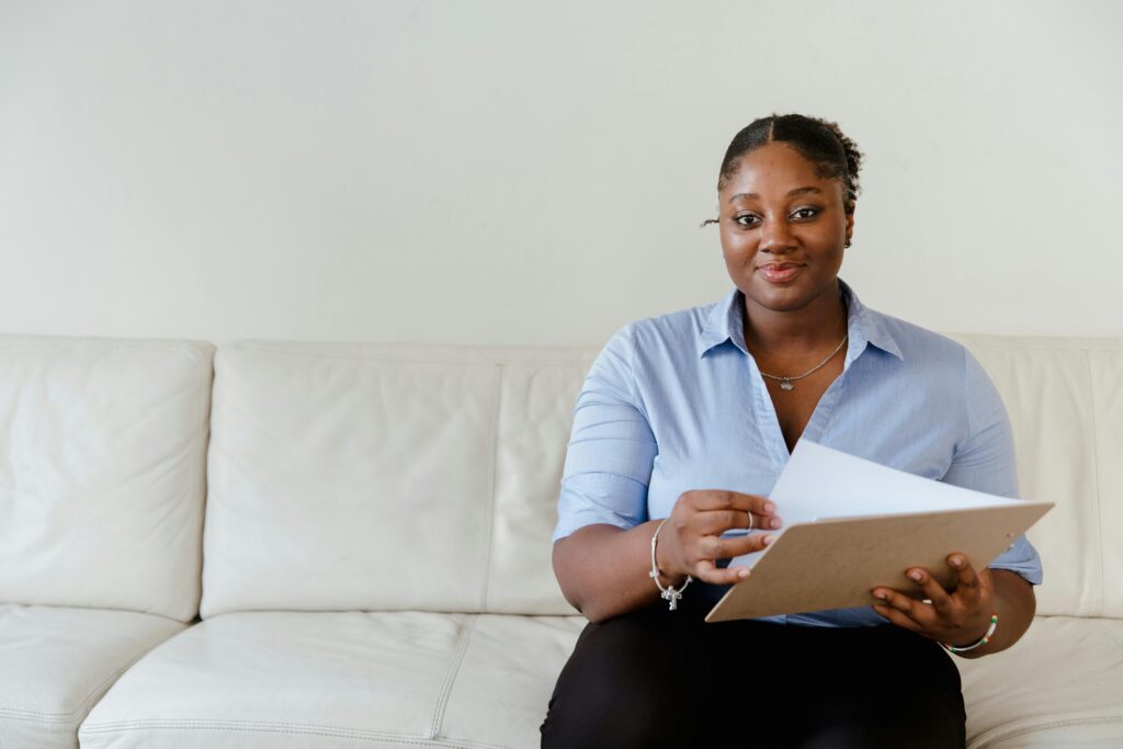 Woman smiles are the camera while filing out an application