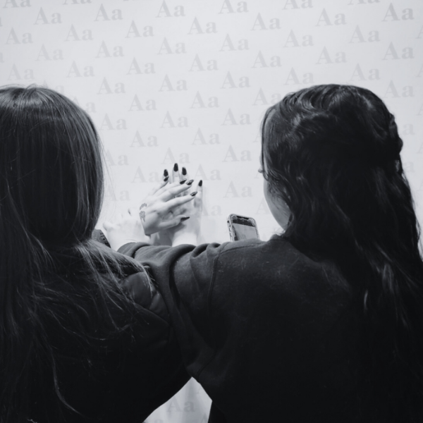 Two students admire and photograph their manicure.